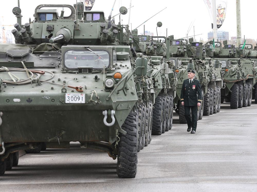 Captain walking beside light armored vehicles