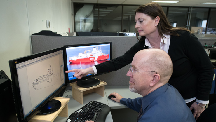 Naval support team collaborating near around a computer screen
